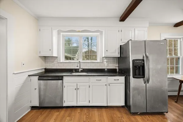 a kitchen with granite countertop a refrigerator and a sink