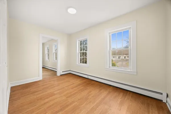 an empty room with wooden floor and windows