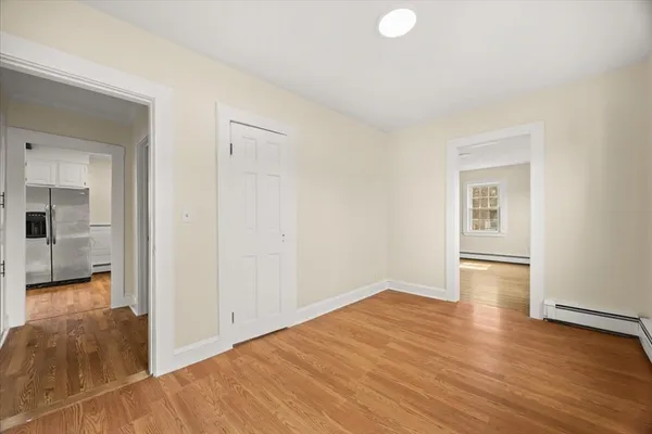 a view of empty room with wooden floor