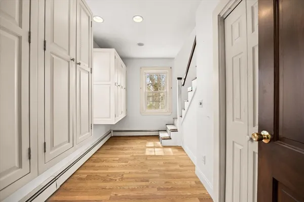 a view of a hallway with wooden floor and staircase