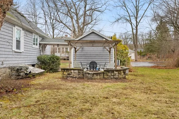 a view of house with backyard and sitting area