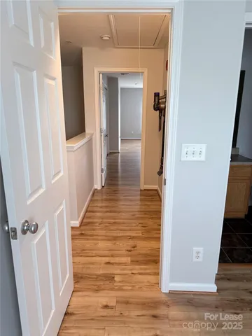 a view of a hallway with wooden floor and staircase