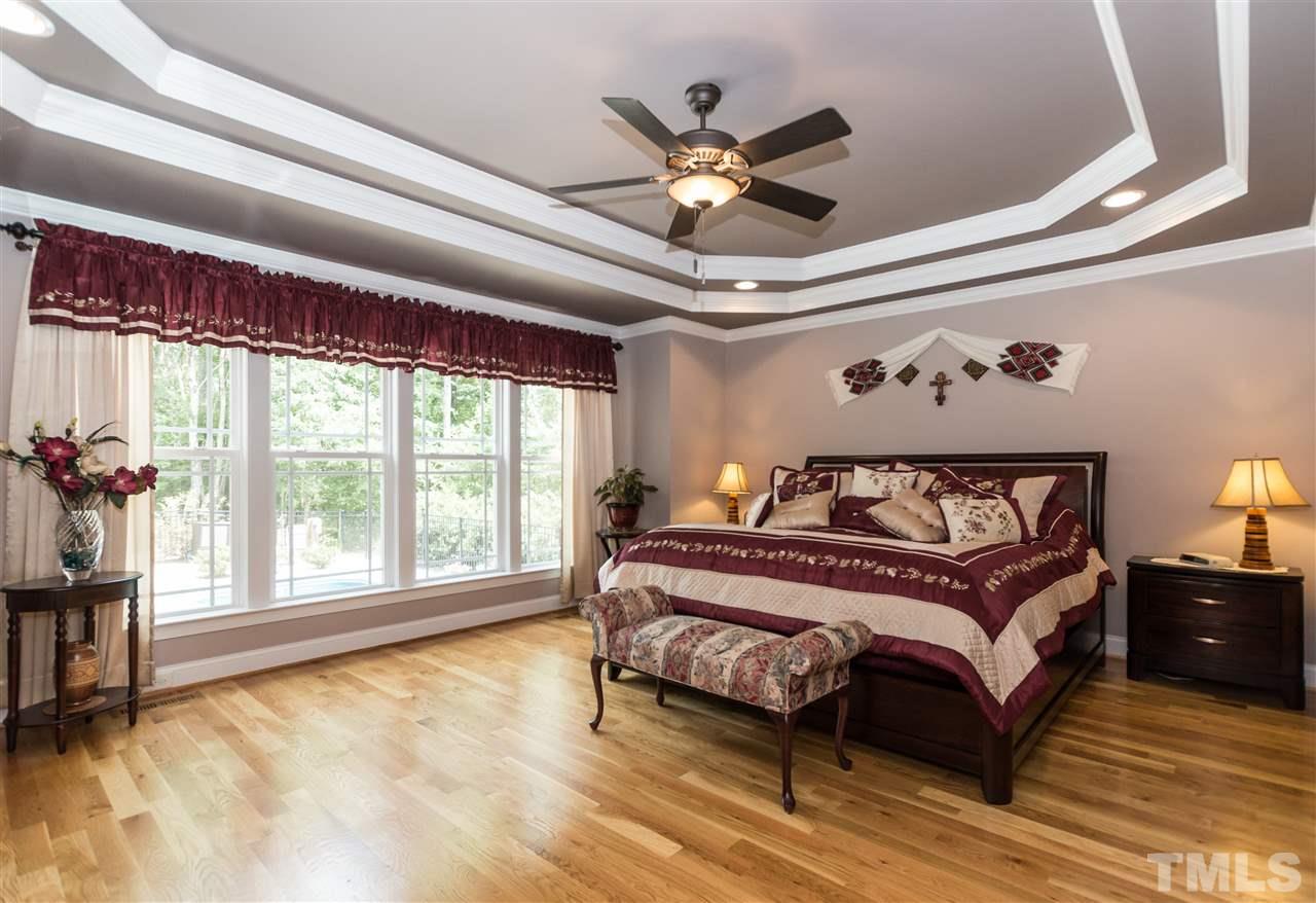 4805 Stoneyoak Lane Raleigh, NC 27610 - Photo 13 of 25 a spacious bedroom with a large bed and a chandelier
