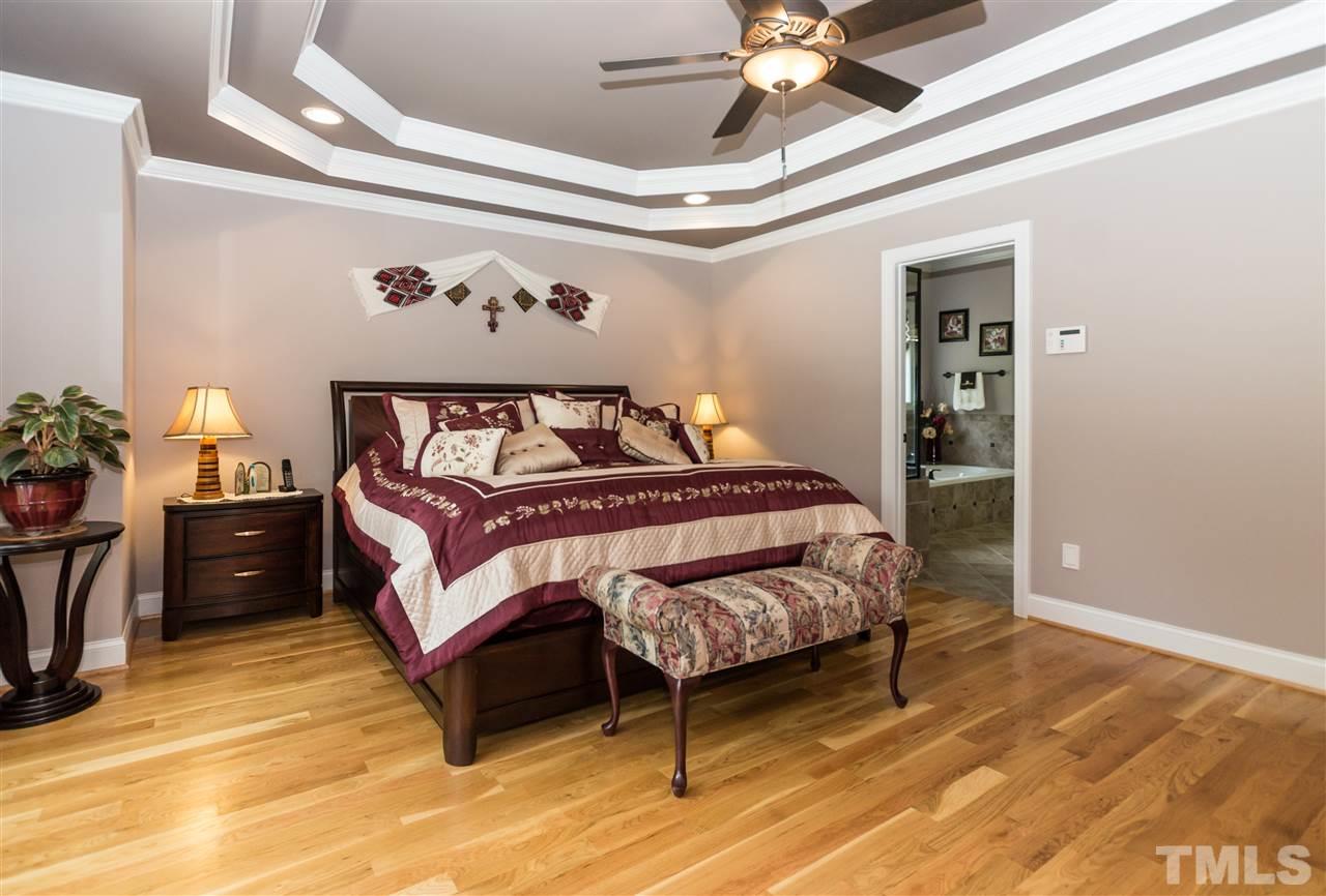4805 Stoneyoak Lane Raleigh, NC 27610 - Photo 14 of 25 a bedroom with a bed and a chandelier