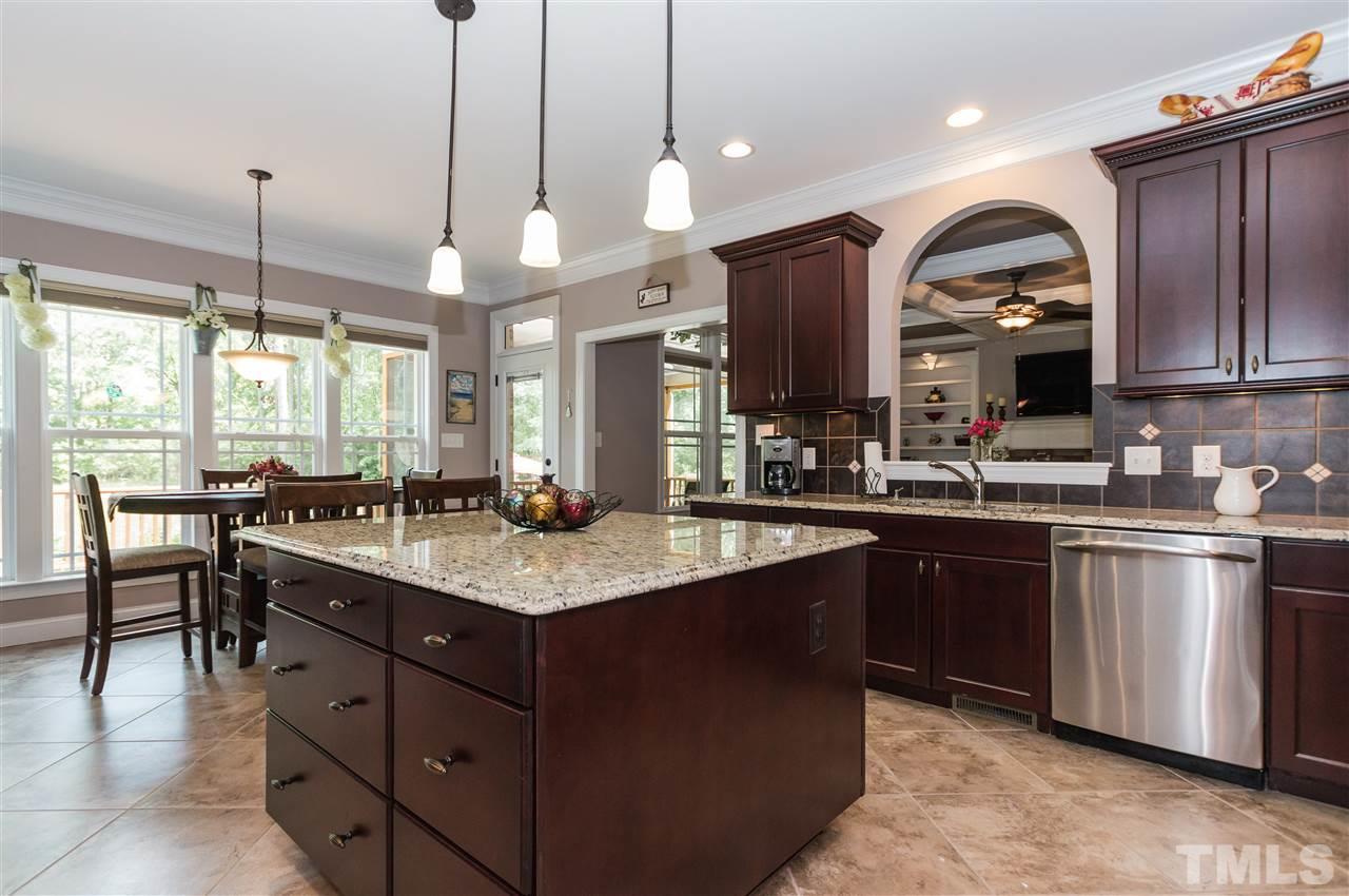 4805 Stoneyoak Lane Raleigh, NC 27610 - Photo 9 of 25 a kitchen with stainless steel appliances granite countertop a sink a stove and a wooden floors