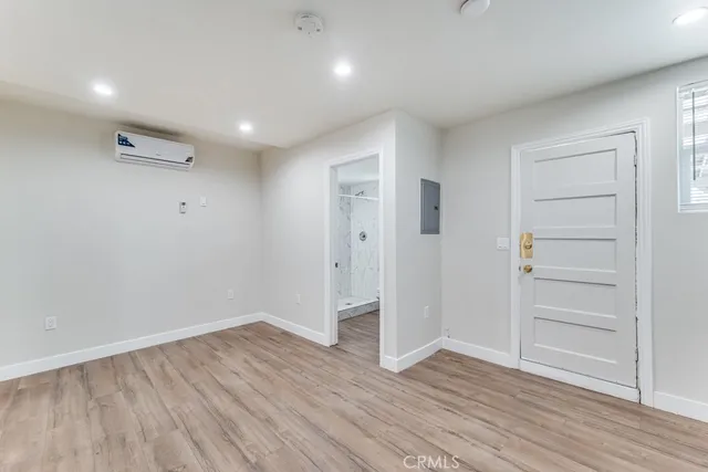 an empty room with wooden floor & closet area