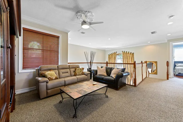 a living room with furniture a flat screen tv and a wall painting