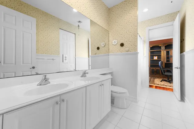 a bedroom with a bed ceiling fan and a wooden floor