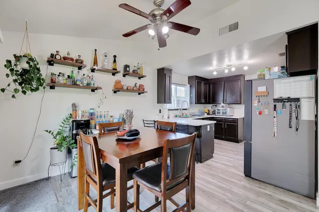a kitchen with stainless steel appliances kitchen island granite countertop a table chairs and a refrigerator