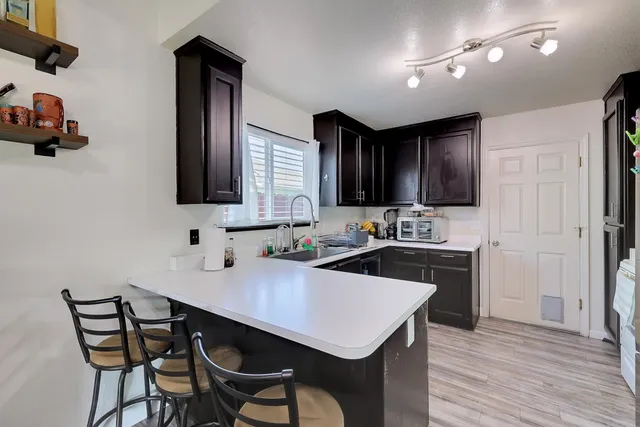 a kitchen with a sink cabinets and wooden floor