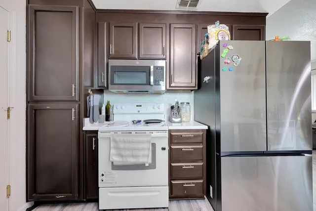 a kitchen with stainless steel appliances a refrigerator stove and microwave