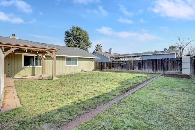 a view of a house with backyard and sitting area