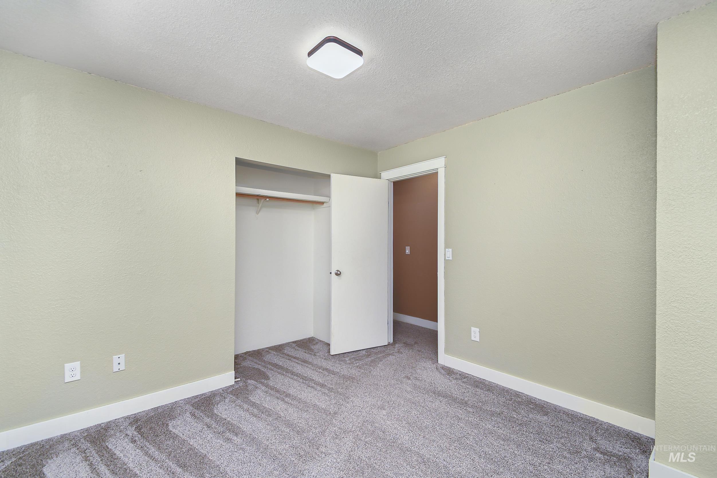 1108 East Ustick Road Caldwell, ID 83607 - Photo 21 of 30 Neutral-toned room featuring a closet with bi-fold doors, white trim, and light gray patterned carpeting