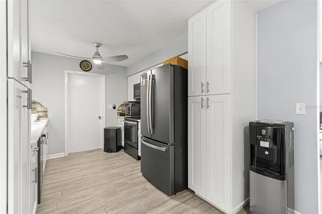 a kitchen with a refrigerator a stove top oven and cabinets
