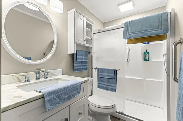 a bathroom with a granite countertop sink mirror vanity and toilet