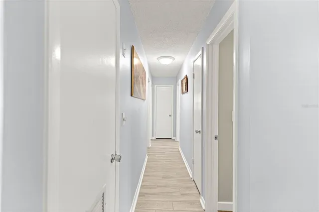 a view of a hallway with wooden floor
