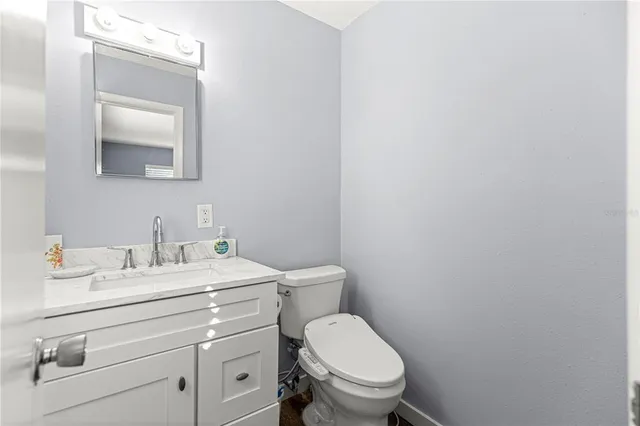 a bathroom with a toilet sink vanity and mirror