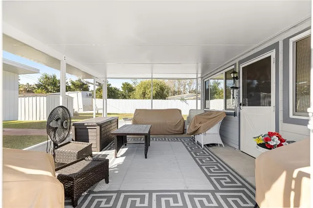 a living room with furniture fireplace and large windows