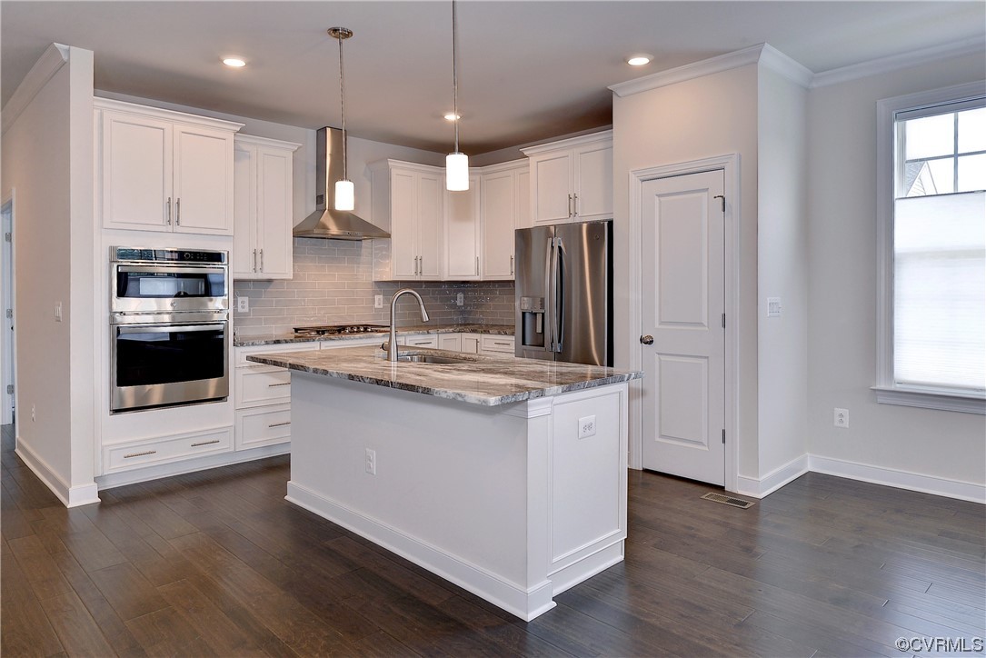 3975 Isaac Circle Williamsburg, VA 23188 - Photo 7 of 36 a kitchen with stainless steel appliances granite countertop a stove a refrigerator and a microwave oven with white cabinets