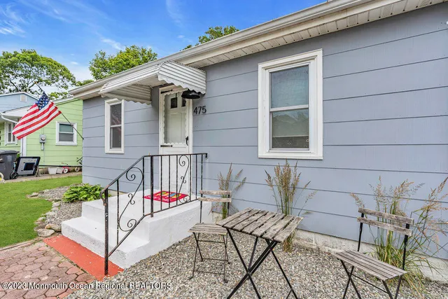 a view of a house with backyard and sitting area