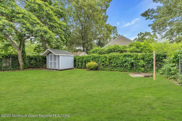 a backyard of a house with lots of plants and large tree