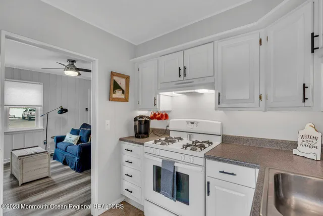 a kitchen with a stove and white cabinets