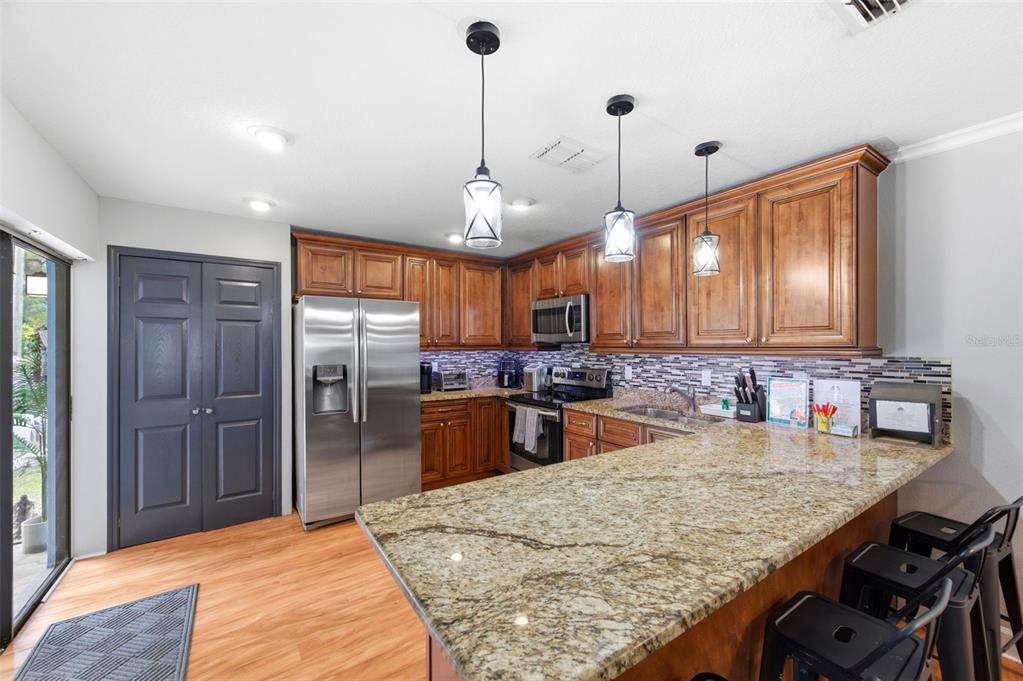 2816 Rustic Oaks Drive Palm Harbor, FL 34684 - Photo 20 of 70 a kitchen with stainless steel appliances granite countertop wooden cabinets a refrigerator and a sink