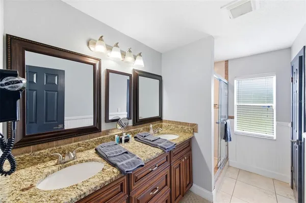 a bathroom with a granite countertop sink toilet mirror and shower