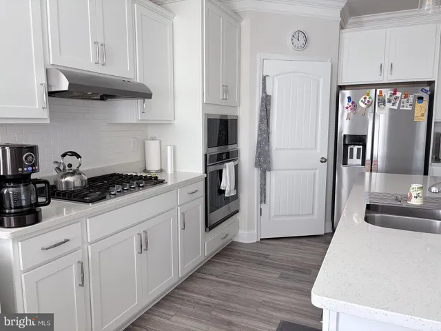 a kitchen with stainless steel appliances granite countertop a refrigerator and a stove