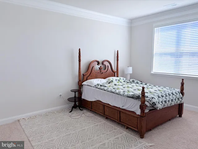a bed sitting in a bedroom next to a window