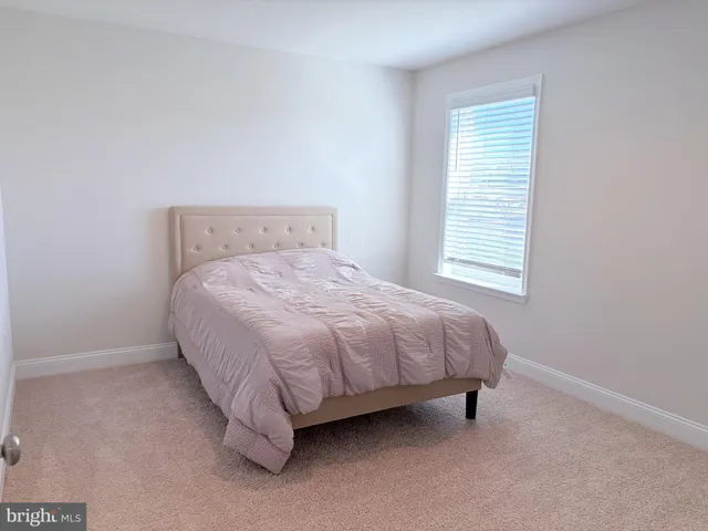 a bed sitting in a bedroom next to a window