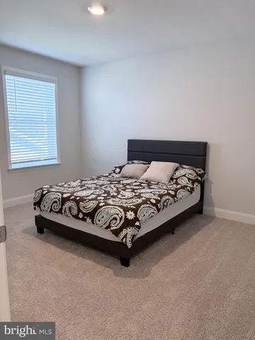 a bed sitting in a bedroom next to a window