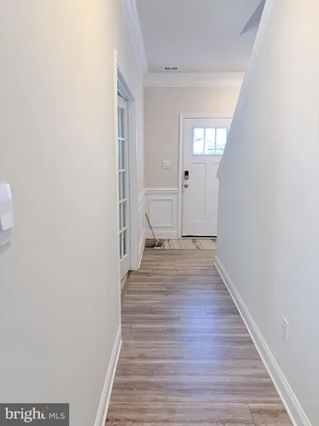 a view of a hallway with wooden floor and staircase