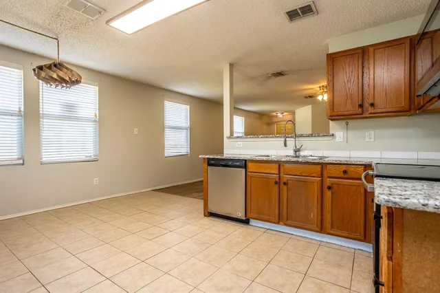a kitchen with granite countertop a sink cabinets and window
