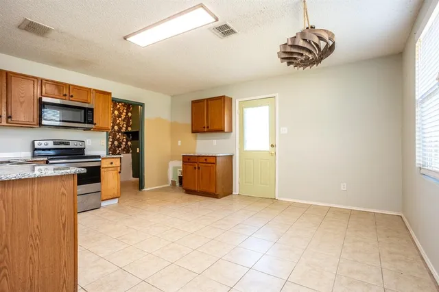 a kitchen with stainless steel appliances a refrigerator and a stove top oven