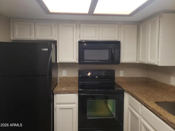 a kitchen with stainless steel appliances granite countertop a refrigerator and a stove top oven