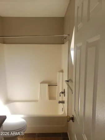 a bathroom with a toilet and a bath tub