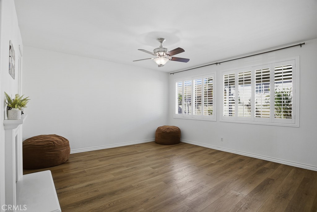 6865 Hop Clover Road Eastvale, CA 92880 - Photo 15 of 59 a view of an empty room with wooden floor and fan