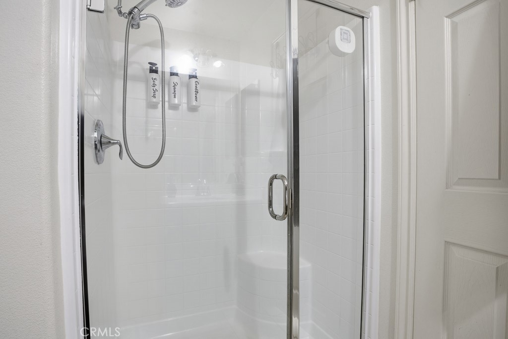 6865 Hop Clover Road Eastvale, CA 92880 - Photo 23 of 59 a bathroom with a glass shower door