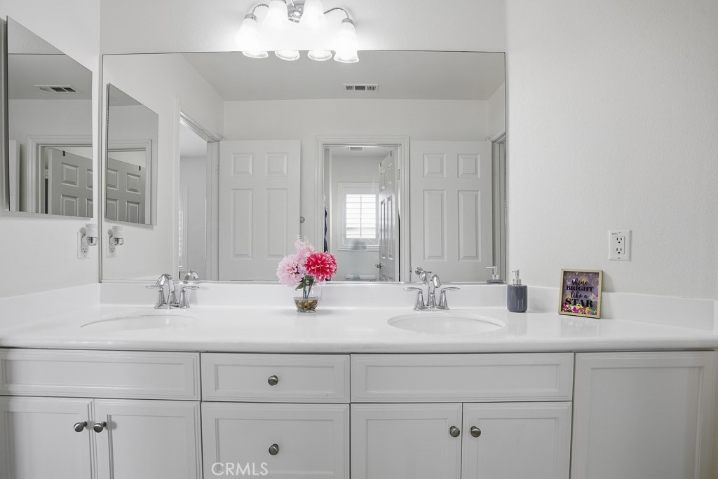 6865 Hop Clover Road Eastvale, CA 92880 - Photo 35 of 59 a bathroom with a sink vanity and a mirror