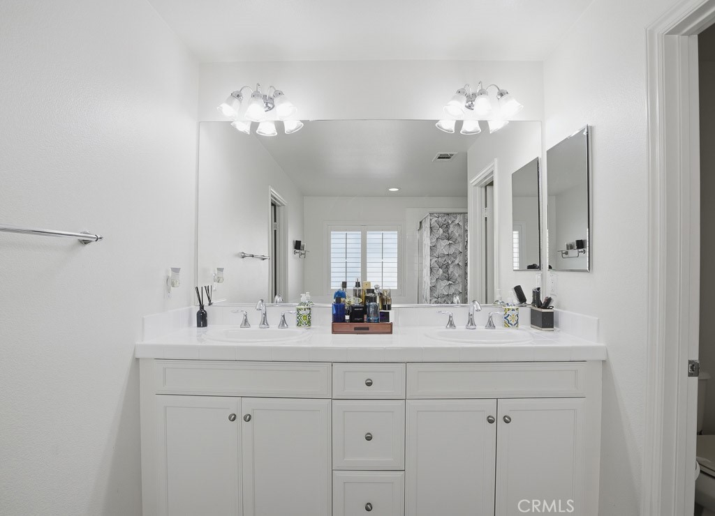 6865 Hop Clover Road Eastvale, CA 92880 - Photo 46 of 59 a bathroom with a double vanity sink double and mirror