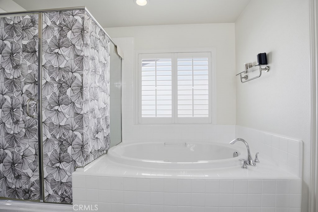 6865 Hop Clover Road Eastvale, CA 92880 - Photo 49 of 59 a bathroom with a bathtub and shower