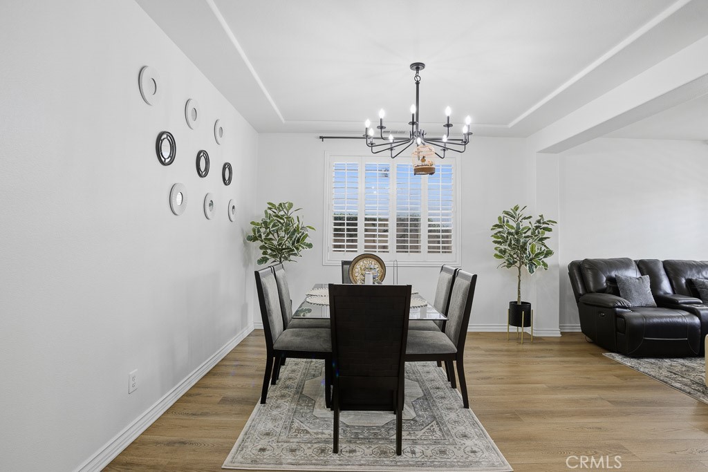 6865 Hop Clover Road Eastvale, CA 92880 - Photo 7 of 59 a view of a dining room with furniture and chandelier