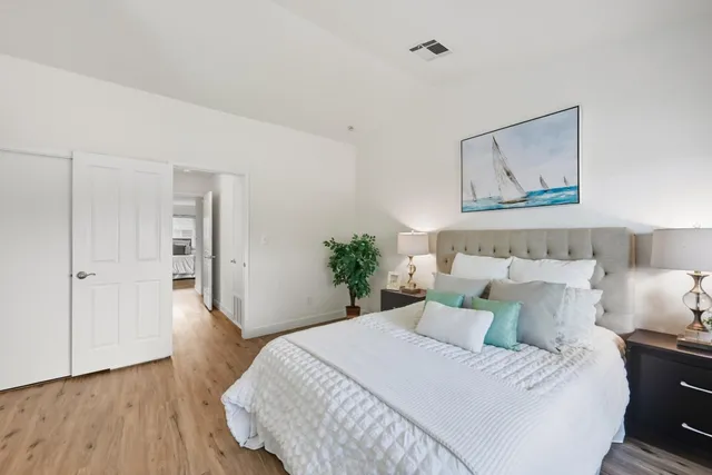 a bedroom with a bed and a painting on the wall