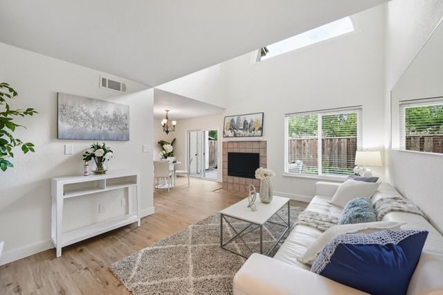a living room with furniture a large window and a fireplace