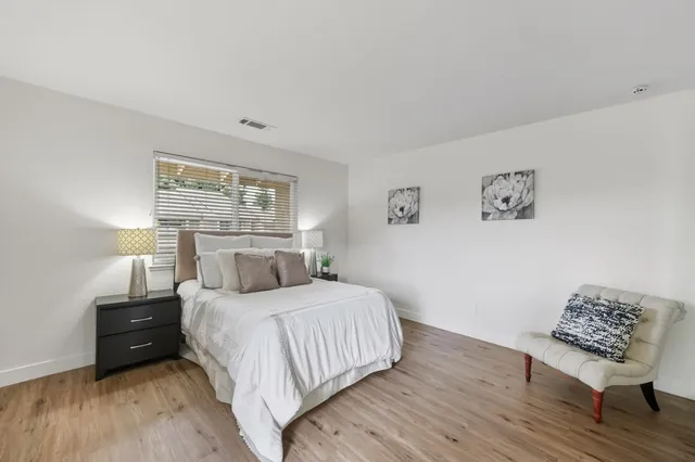 a bedroom with a bed lamp and a large window
