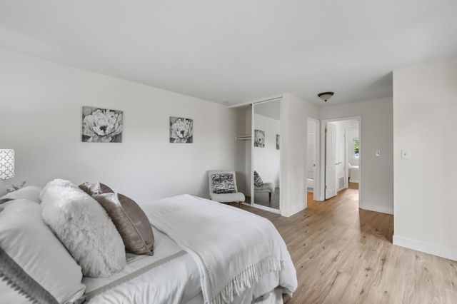a bedroom with a bed and a painting on the wall