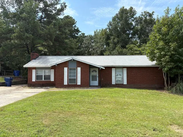 a front view of a house with yard and trees