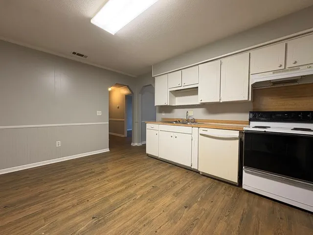 a kitchen with granite countertop a sink cabinets and stainless steel appliances