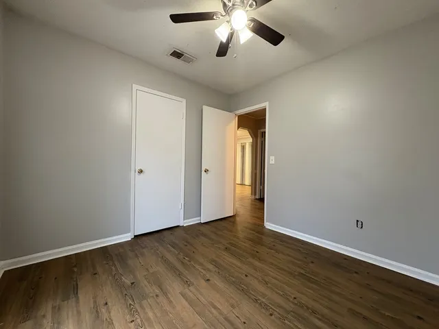 a view of an empty room with wooden floor